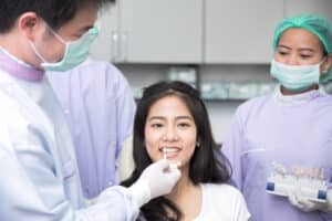 Dentist comparing patient's teeth shade