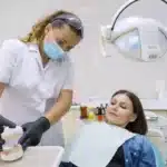 Adult dentist treating woman