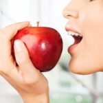 woman about to bite an apple